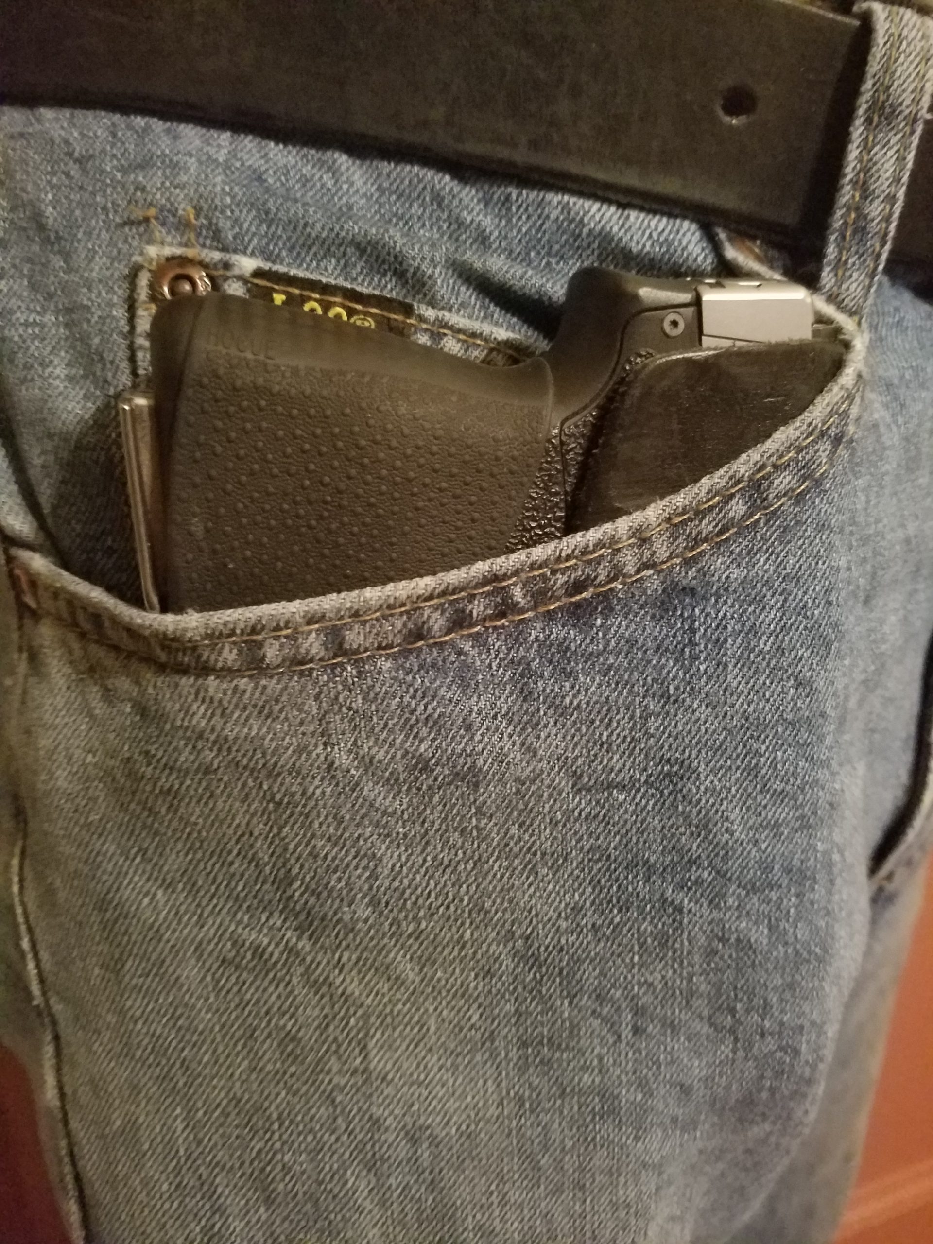 Image of gun holstered in Pocket Watch Holster shown clipped onto jeans watch pocket.